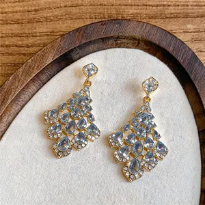 Detail of elegant gold drop earrings with light blue teardrop crystals and rhinestones