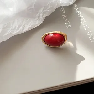 Nahaufnahme eines goldenen Rings im Vintage-Stil mit poliertem rotem Kunstharzstein