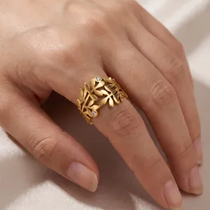Gros plan d'une bague large de 17mm en acier inoxydable avec feuilles d'olivier et pierres