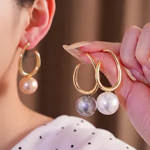 Elegantes pendientes de aro dorados con grandes perlas en blanco, gris y dorado.
