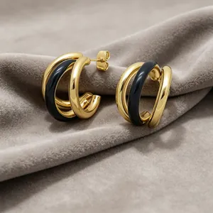 Detailansicht der dreischichtigen C-förmigen Edelstahl-Ohrringe in Gold und Schwarz.