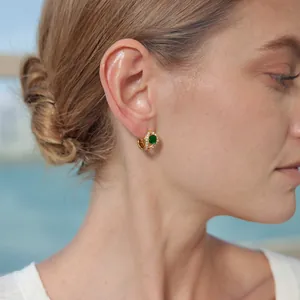 Gros plan d'une boucle d'oreille en or 18 carats avec zircon vert et motif serpent