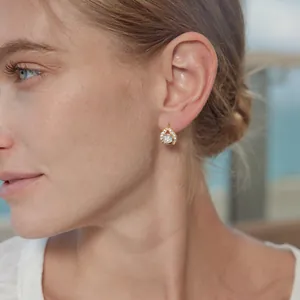Gros plan d'un mannequin portant une boucle d'oreille goutte en or 18 carats et cristaux