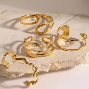 Gedetailleerd overzicht van vier gouden onregelmatige zirkoon armbanden op steen