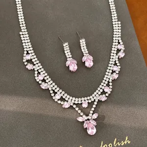 Close-up detail of silver zircon necklace and earring set with pink water drop pendants