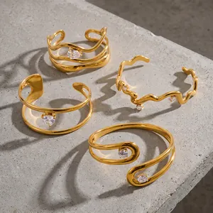 Set van onregelmatige geometrische vergulde roestvrijstalen armbanden met zirkonen.