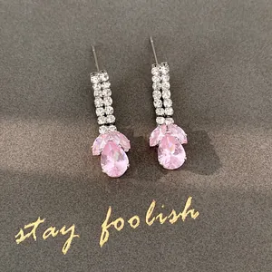 Macro detail view of elegant pink zircon teardrop earrings with double row crystal accents