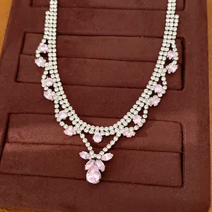 Elegant silver-tone zirconia necklace featuring pink pear-shaped stones on velvet display