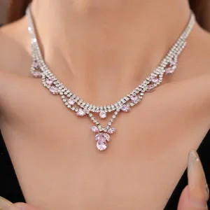 Close-up of an elegant necklace featuring pink teardrop zircons and clear rhinestones.