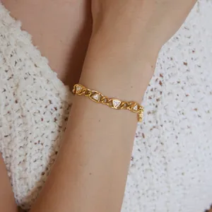 Detailansicht eines goldenen Titanstahl-Armbands mit dreieckigen Zirkonia-Einlagen.