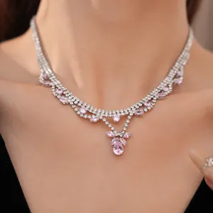 Close-up of elegant silver necklace with pink and clear zircon teardrop pendants.