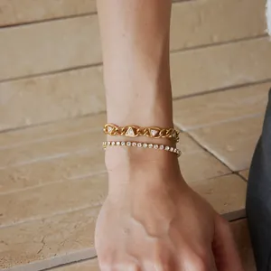 Detailansicht eines Titanstahl-Armbands mit Zirkonia-Dreieck und Tennis-Armband am Handgelenk