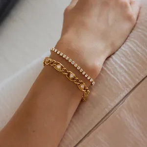 Nahaufnahme eines goldenen Edelstahlarmbands mit Dreieck-Zirkonias und Tennis-Kette