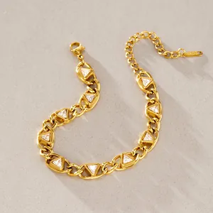 Detail eines Armbands aus goldfarbenem Titanstahl mit dreieckigen weißen Zirkonia-Inlays