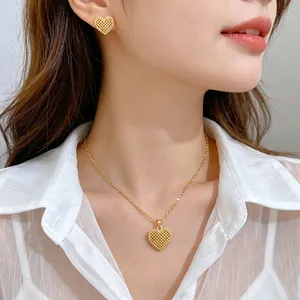 Close-up of golden hollow heart necklace and earrings jewelry set worn by Asian model