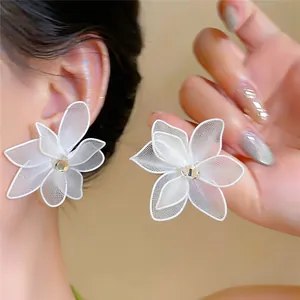 Detailopname van elegante witte mesh bloemoorbellen met een glanzend zirkonia midden.