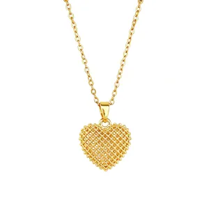 Detailed view of a gold-tone titanium steel heart pendant with intricate hollow lattice design
