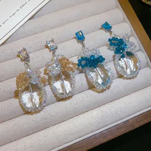 Elegante Ohrhänger mit blauen und champagnerfarbenen Kristallen in einer Schmuckschale