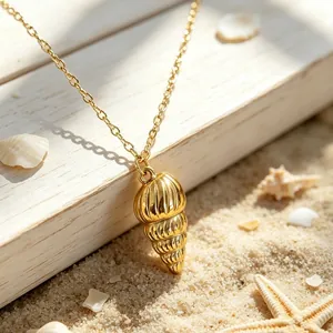 Close-up of golden stainless steel conch shell pendant on a sunny beach background