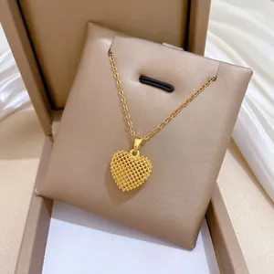 High-definition close-up of a gold-plated titanium steel mesh heart pendant on a chain