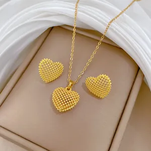 Close-up of elegant titanium steel gold mesh heart necklace and earring jewelry set