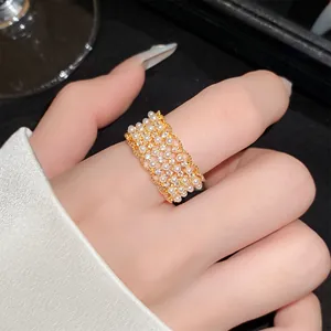 Elegante 18-karaats vergulde kantring met parels en zirkonia op de modelvinger