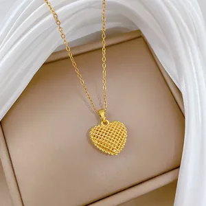 Detail showing gold hollow mesh heart pendant on a delicate chain in a gift box.