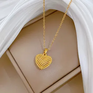 Detailed close-up of a gold-plated titanium steel heart pendant with hollow mesh texture