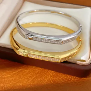 Close-up of luxury 18K gold and silver plated oval bangles with micro-pave cubic zircons