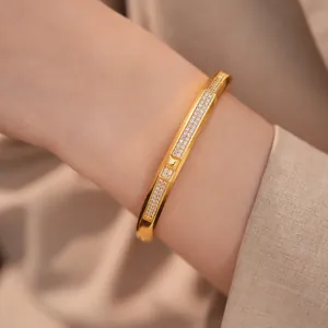 Close-up of an elegant 18K gold-plated oval bangle with micro-paved sparkling zircons