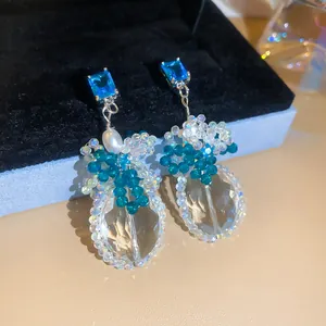 Close-up van elegante blauwe zirkoon en kristallen kralen oorbellen in de doos