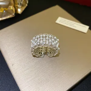 Gedetailleerd overzicht van een 18k vergulde kanten open ring met parels en zirkoon.