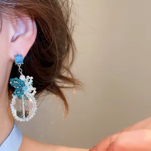 Elegante blauwe zirkoon kristallen kralen oorbellen detail met een helder kristal.