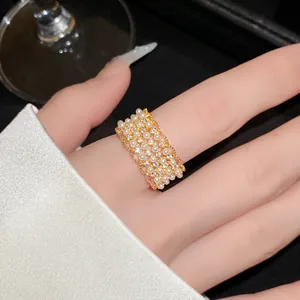 Detailopname van elegante 18k vergulde kantring met delicate parels en zirkonia-steentjes