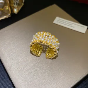 Prachtige 18k vergulde open ring met ingewikkelde details van parels en zirkonia