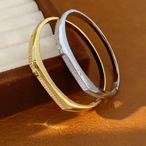 Detail view of 18K gold plated oval bangles with shimmering micro-set cubic zirconia.