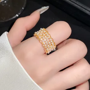 Detailweergave van een 18k vergulde kanten ring met kleine parels en zirkonia's.