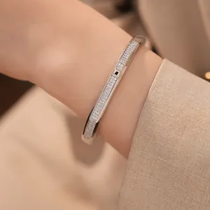 Close-up of elegant 18K white gold plated bangle with pave-set cubic zirconia on wrist.