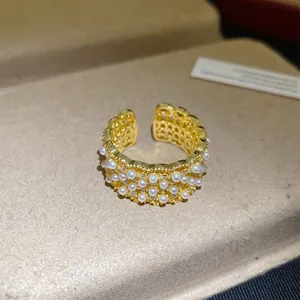 Gedetailleerd overzicht van een 18k vergulde open ring met elegante parels en zirkoonstenen