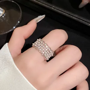 Detailopname van een 18k vergulde kanten ring met witte parels en zirkonia's