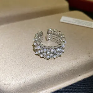 Gedetailleerd overzicht van het holle kantontwerp van deze parel en zirkoon ring