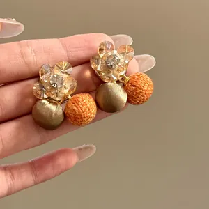 Gedetailleerd overzicht van zirkoonbloemenoorbellen met satijnen en stoffen bollen