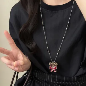 Collier de perles en verre ours vintage avec nœud rouge porté sur un t-shirt noir