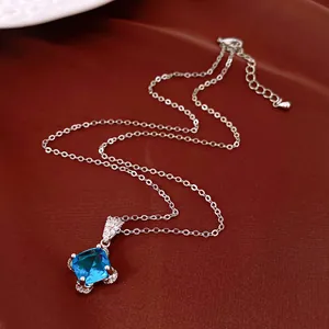 Detail of a French style necklace with a square blue zircon pendant on a silver chain.