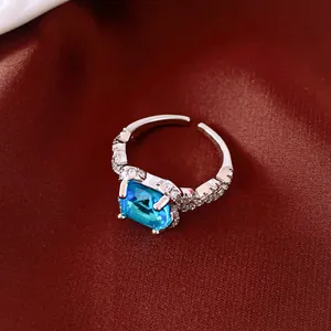 Close-up detail of French vintage square blue zircon adjustable ring on red silk fabric