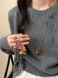 Vue détaillée d'un long collier vintage avec de mignons pendentifs en forme d'ours.
