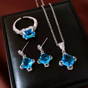 Close-up of elegant jewelry set featuring vibrant square blue stones and silver finish