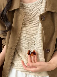 Gros plan d'un collier de perles vintage avec un adorable pendentif en forme de Scottie.