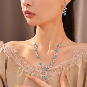 Elegant silver-toned leaf and blue flower rhinestone necklace and earring set on model