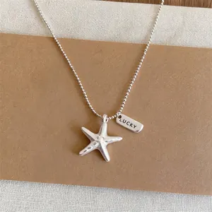 Silver starfish pendant necklace with LUCKY tag on ball chain for summer beach style.